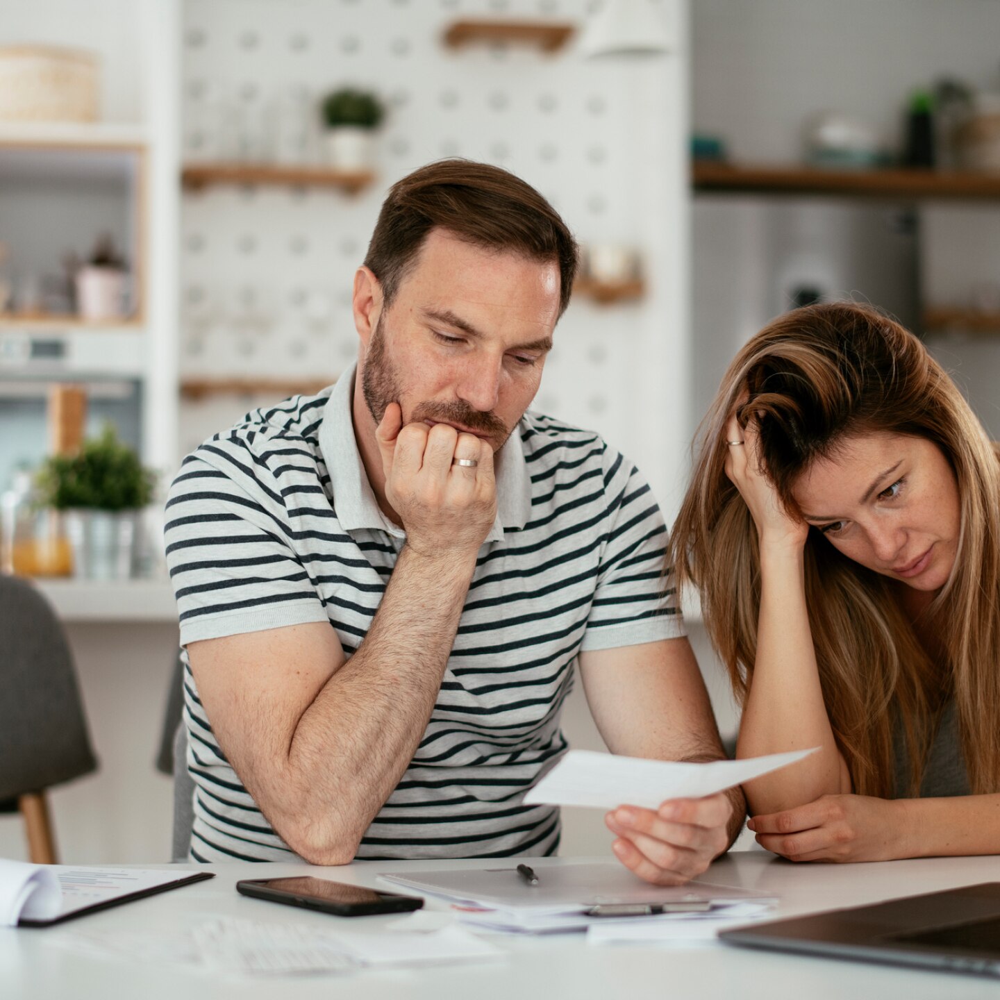 sorgenvolles-paar-schaut-auf-ein-blatt-papier