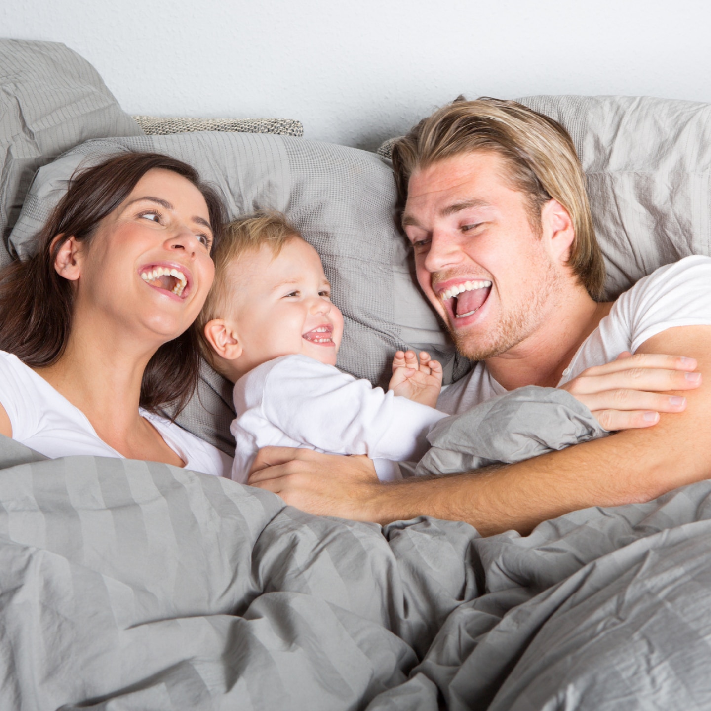 paar und baby im bett