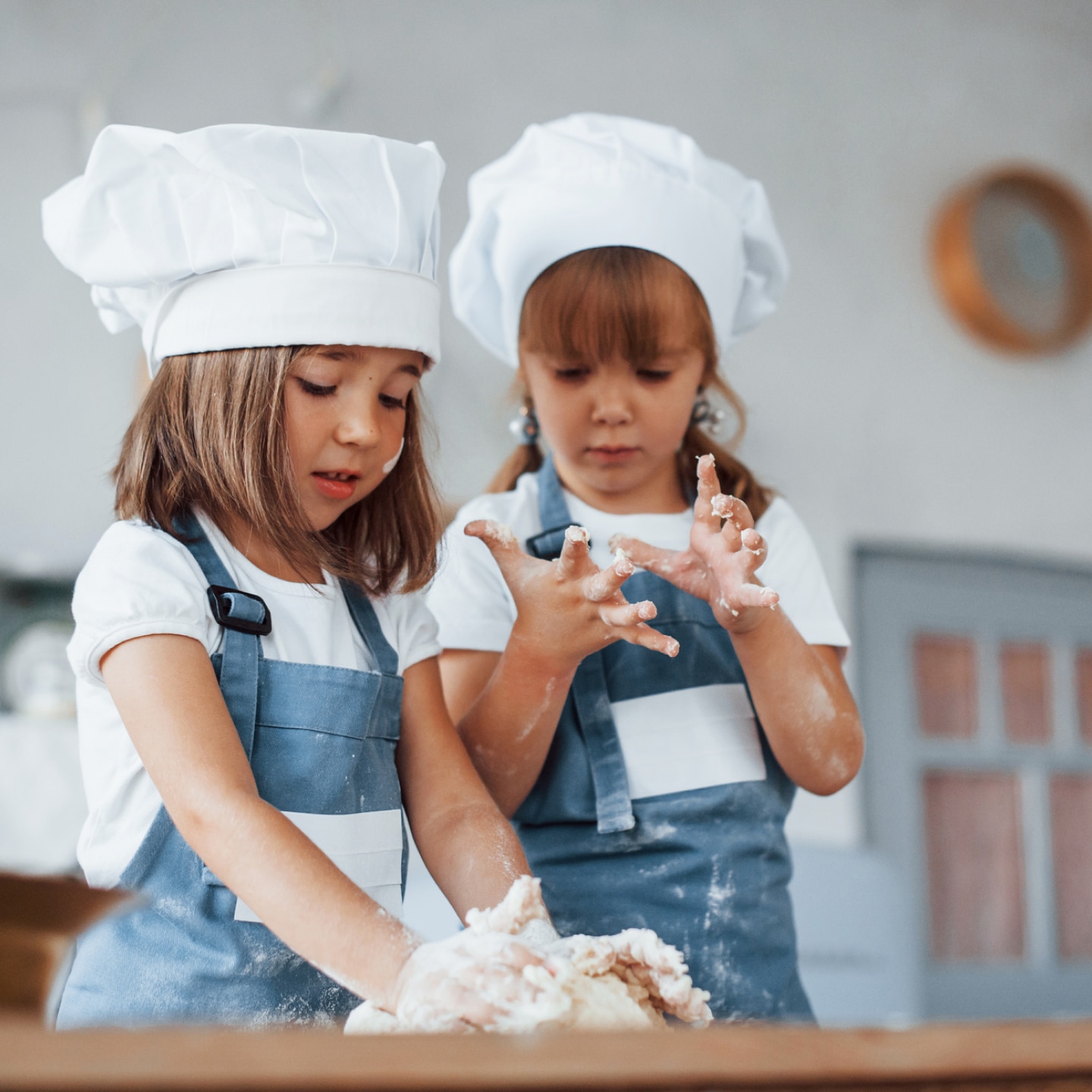 zwei-mädchen-mit-schürzen-am-backen