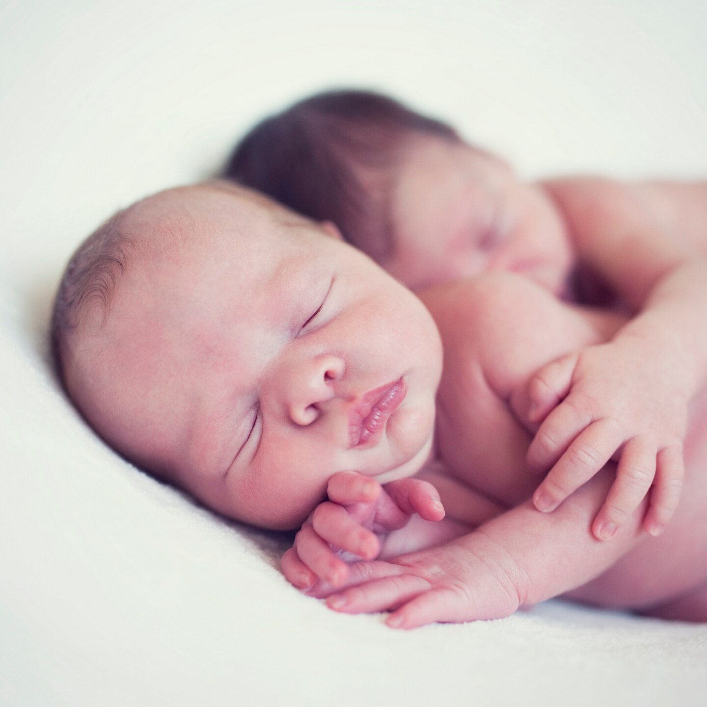 zwei-neugeborene-die-sich-im-schlaf-umarmen