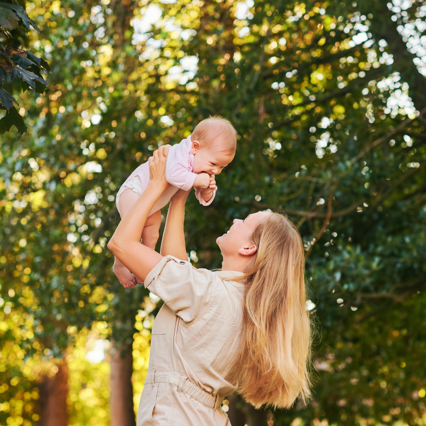 mutter-hebt-baby-in-die-luft