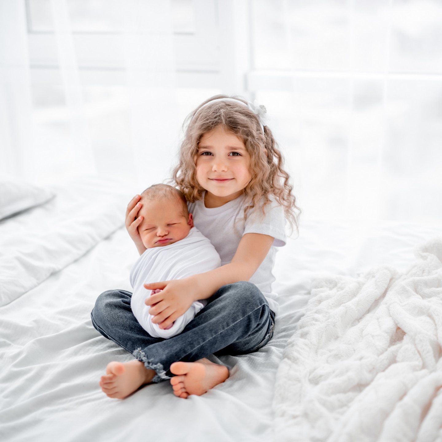 große-schwester-hält-baby-im-arm