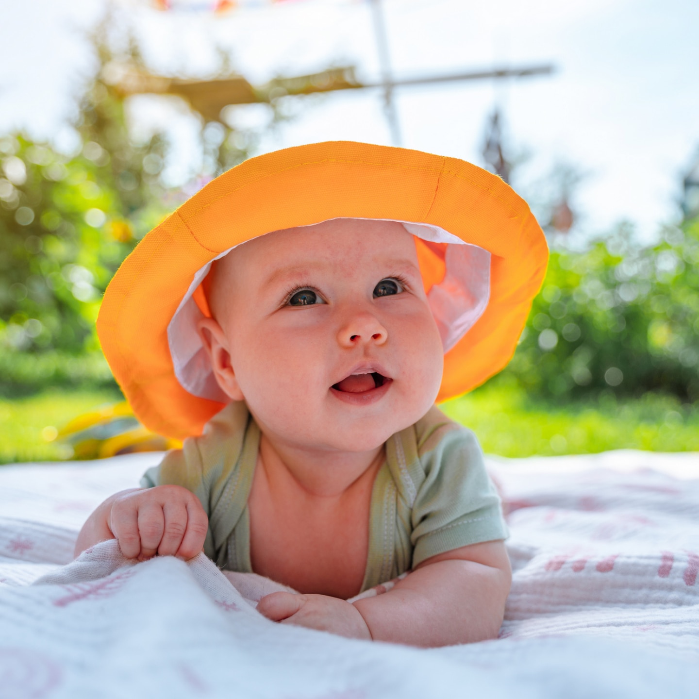 baby-mit-sonnenhut-auf-wiese