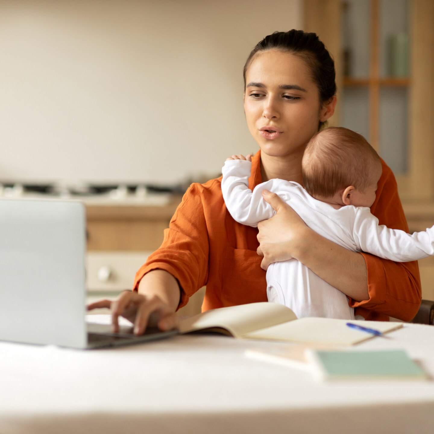 mutter-am-laptop-mit-baby-im-arm