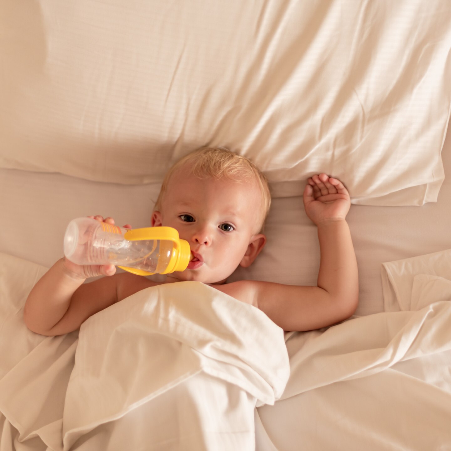 kleinkind-im-bett-mit-fläschchen