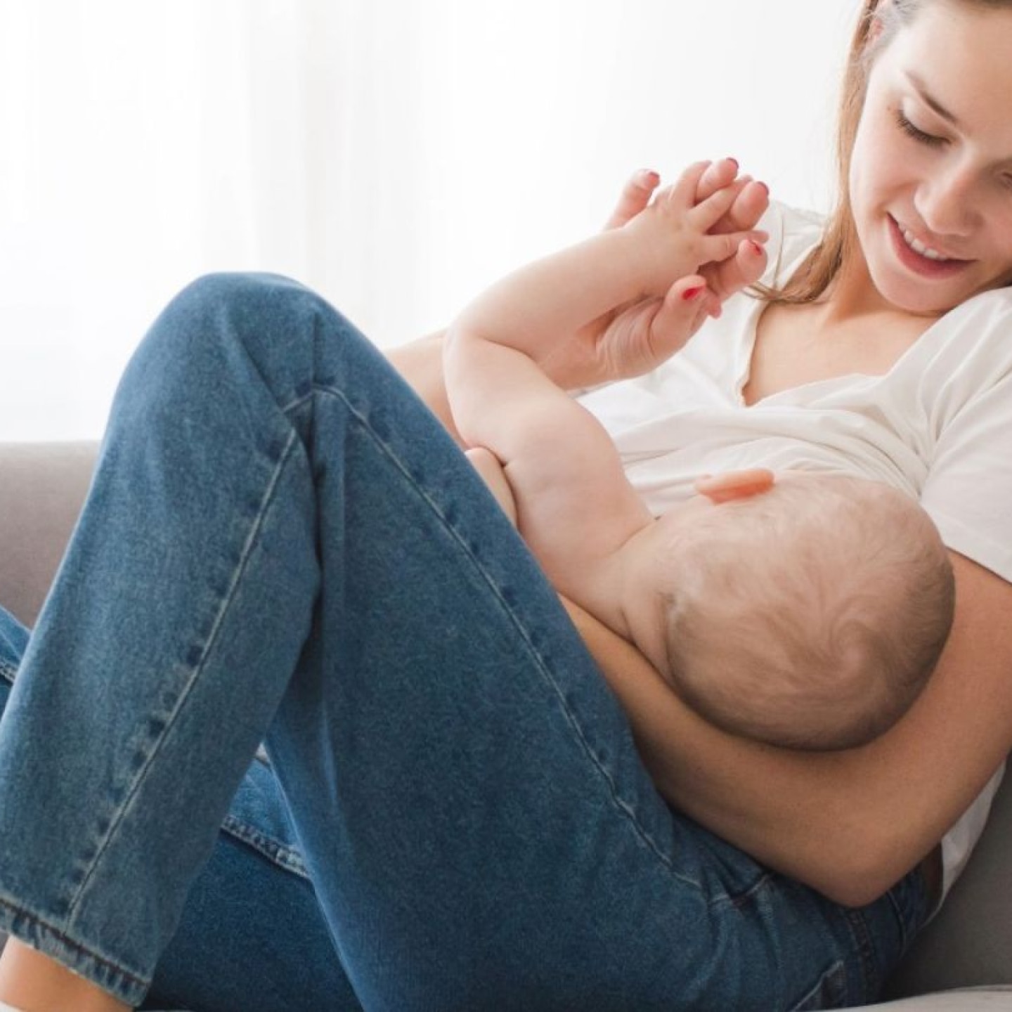 mama stillt ihr baby auf der couch