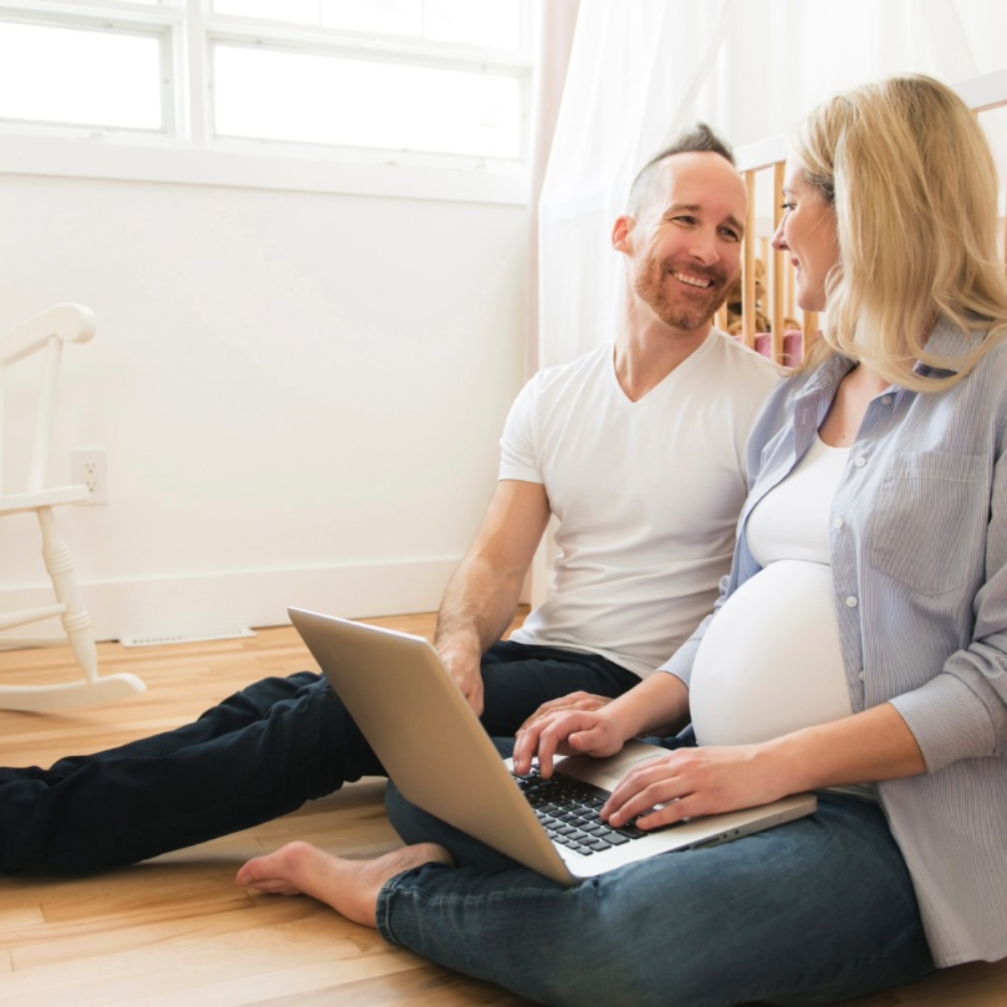 schwangere und partner vor babybett