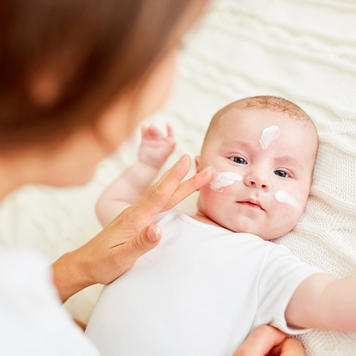 Mutter cremt Baby ein