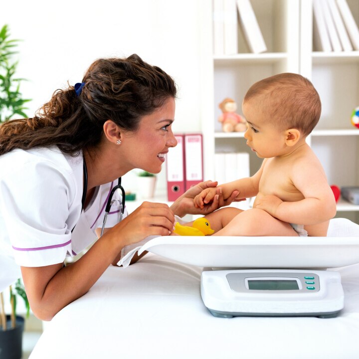 Baby beim Arzt auf der Waage