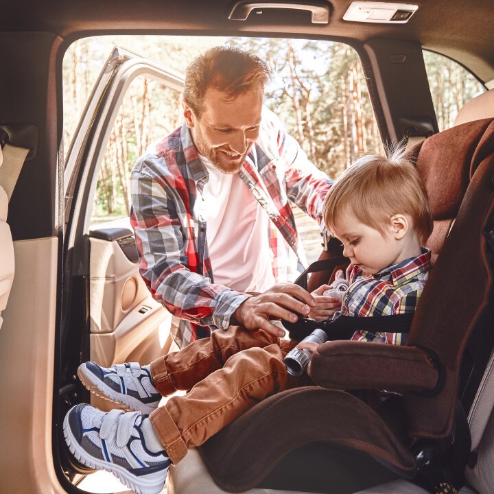 Kind wird angeschnallt im Auto