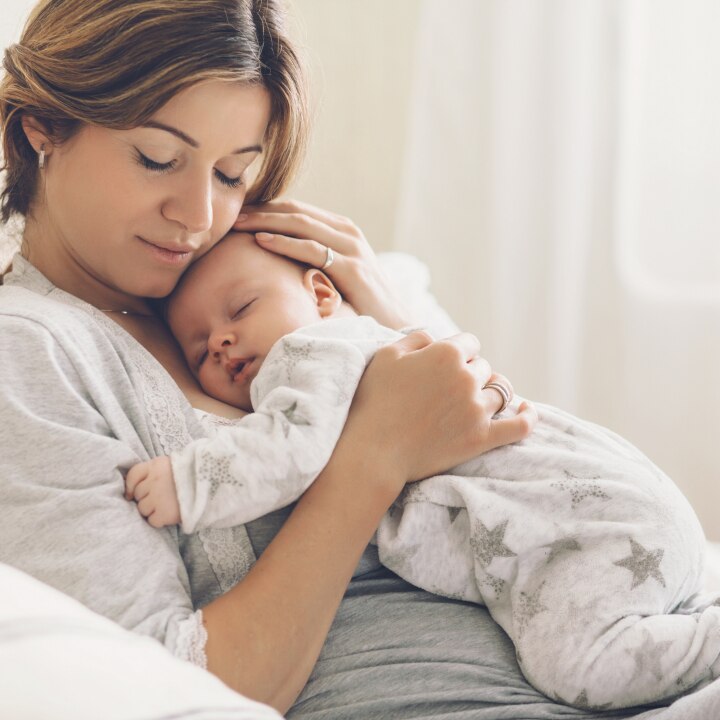 Baby schläft in Mamas Arm