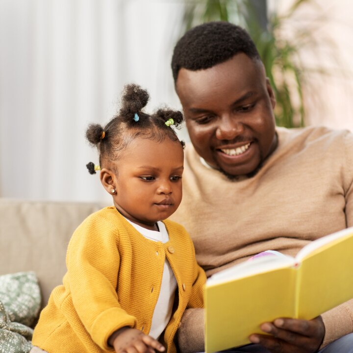 Vater liest Tochter aus dem Buch vor