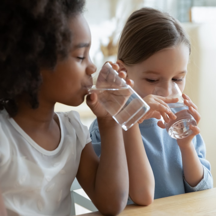 Kinder trinken Glas Wasser