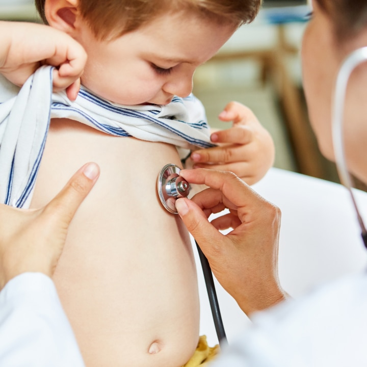 Kinderärztin beim Abhören von Lunge mit Stethoskop