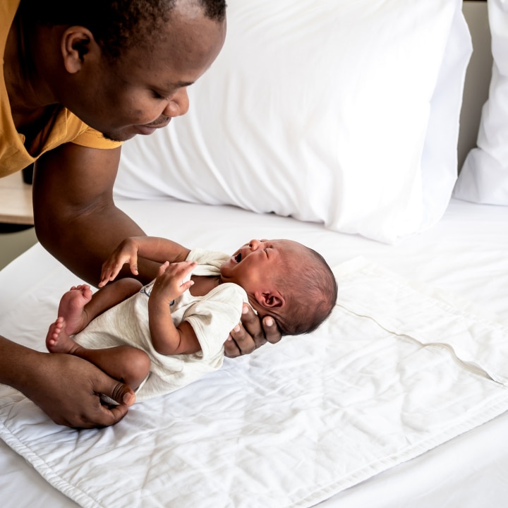 Vater hält schreiendes Baby in den Händen