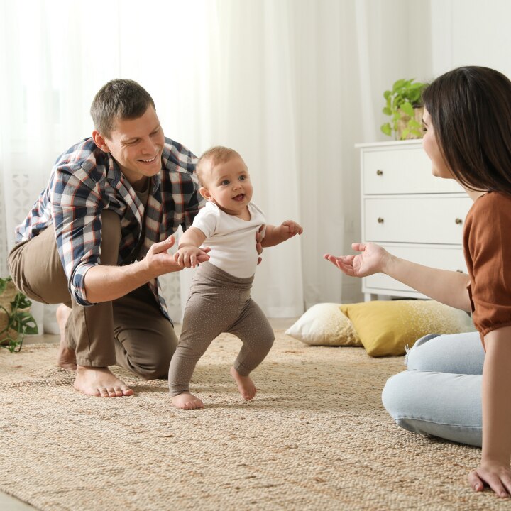 Baby läuft in die Arme der Mutter