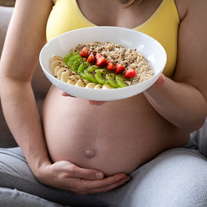Schwangere hält eine Essensbowl