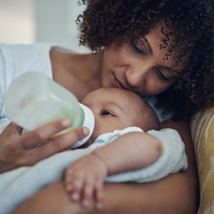 Mutter füttert ihr Baby mit dem Fläschchen
