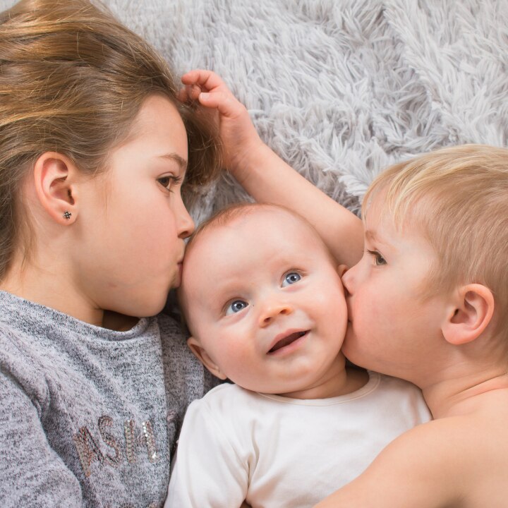 geschwister liegen zusammen im bett