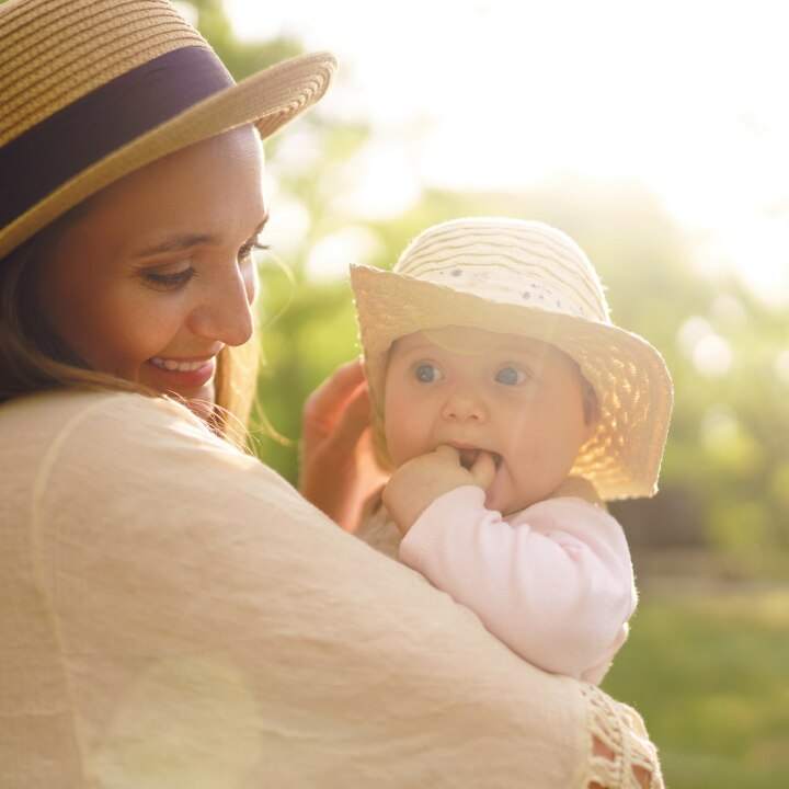 mutter-mit-baby-mit-sonnenhüten-im-sonnenschein