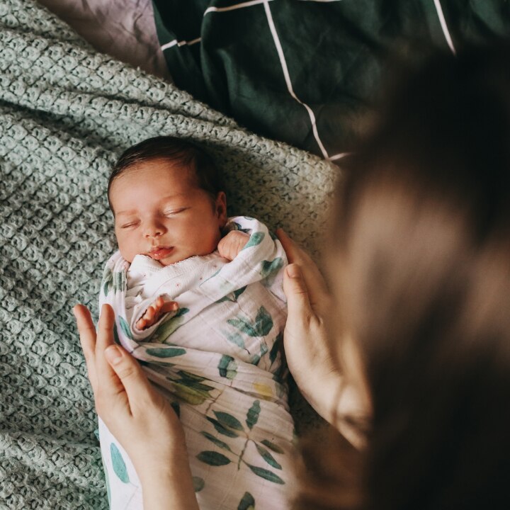 mutter-wickelt-baby-in-decke-ein
