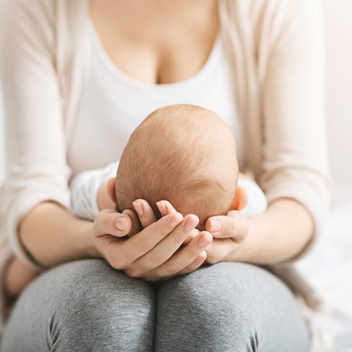 baby-liegt-auf-dem-schoß-der-mutter