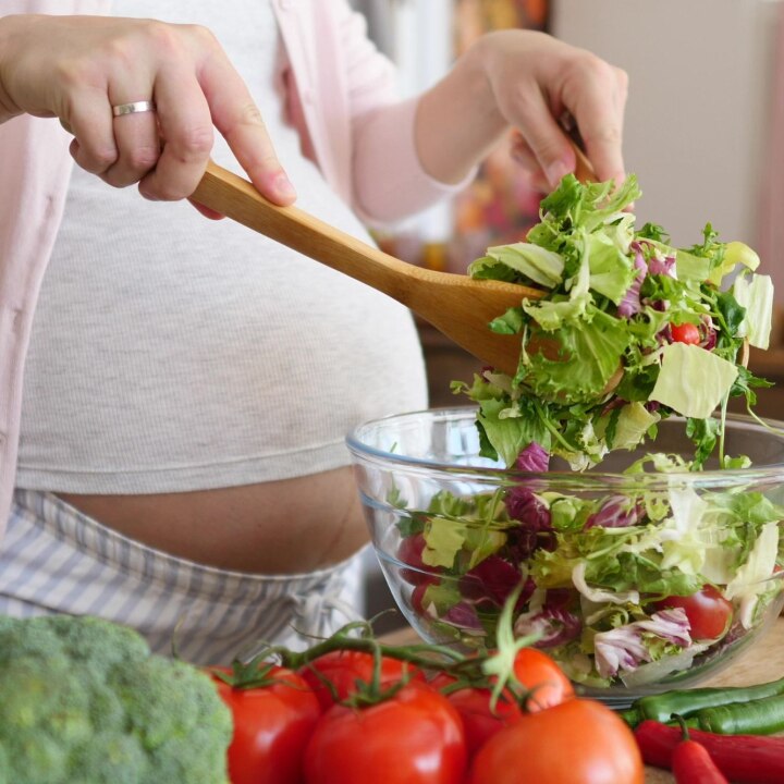 schwangere bereitet einen salat zu