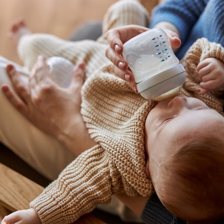 baby bekommt ein flaeschchen von ihrer mama