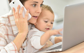 Mutter mit Kind am PC mit Telefon