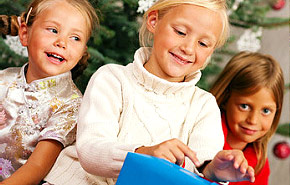 Kinder packen Weihnachtsgeschenke aus